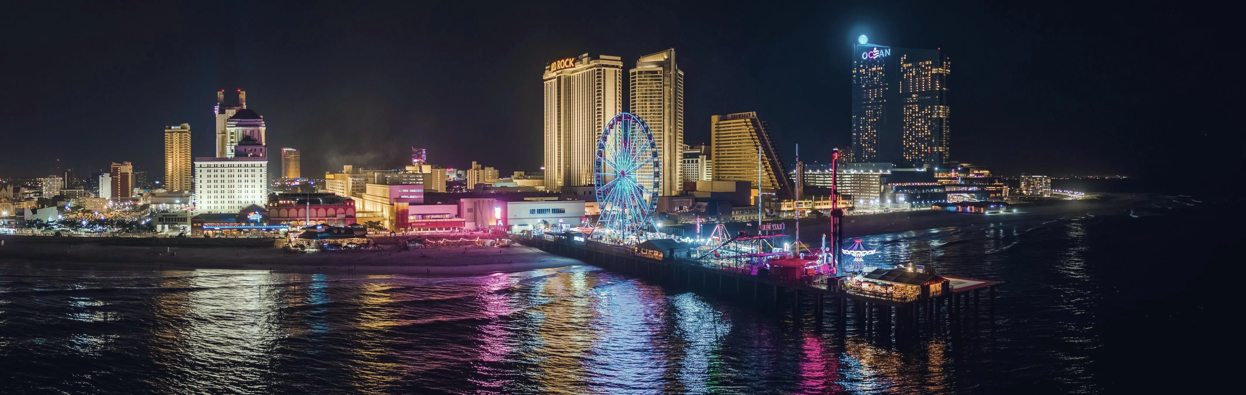 Steel Pier and the Atlantic City skyline lit up at night over the ocean